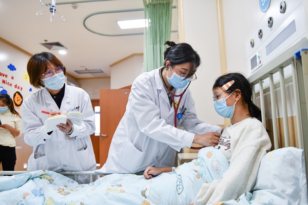 感染科主任醫(yī)師張禎禎（中）檢查住院患者情況。鄒樂攝