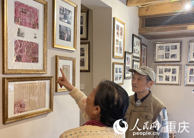 市民仔細(xì)端詳丁勝父母70多年前的結(jié)婚證和照片。人民網(wǎng) 劉祎攝