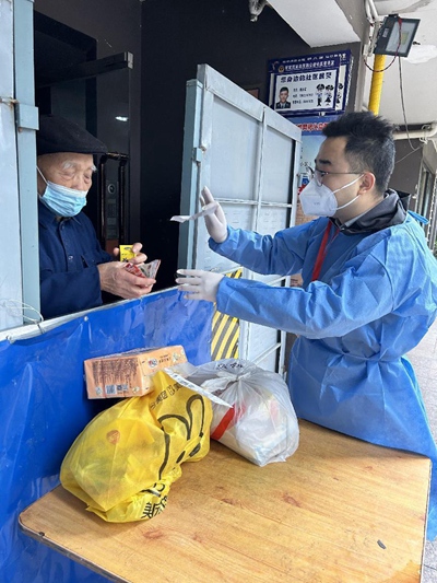 九龍坡區(qū)稅務(wù)局青年黨員志愿者黎禹希（右）把買到的藥交給袁老。重慶市稅務(wù)局供圖