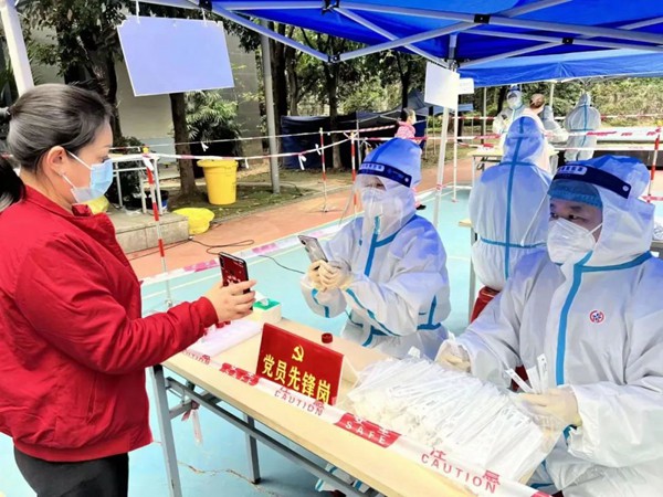 重慶機電集團所屬西計公司黨員賈碧波（右）參與核酸檢測信息采集工作。重慶機電集團供圖