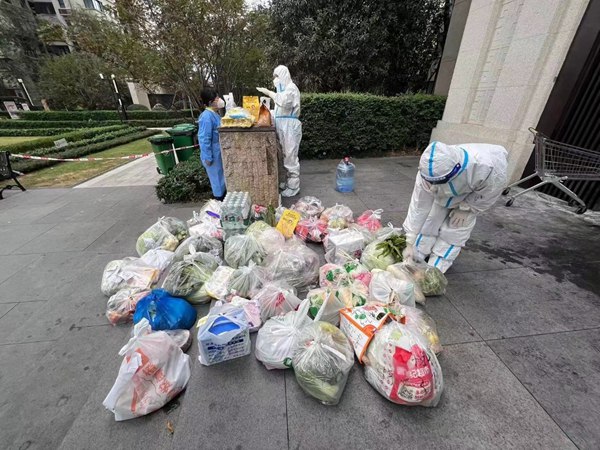 重慶銀行兩江分行黨員楊晶（右）為居民提供無接觸上門配送蔬菜、藥品等服務。重慶銀行供圖