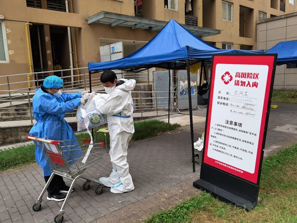 重慶交運集團黨員羅開祿協(xié)助當?shù)厣鐓^(qū)到高風險區(qū)樓棟為住戶送生活物資。重慶交運集團供圖