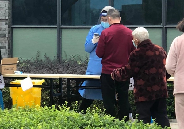 四聯(lián)集團黨員任國偉協(xié)助做好核酸檢測登記工作。四聯(lián)集團供圖