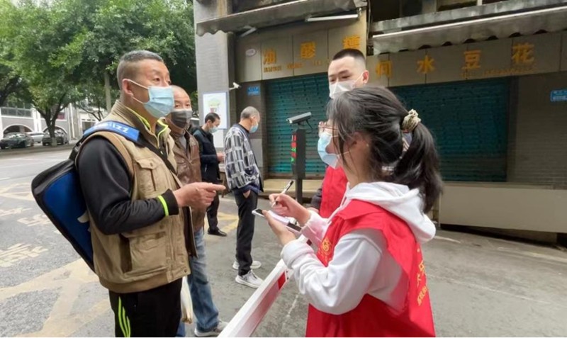 “00后”志愿者秦榕浚一一記下附近居民所需的蔬菜。蔣歡攝