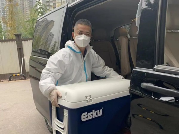 盧行正在往車上搬運物資。