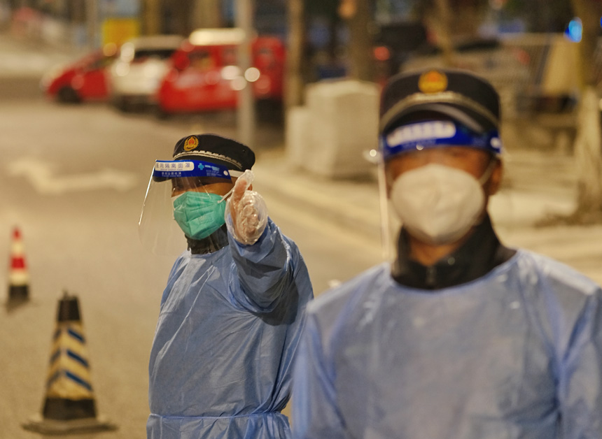 銅元局亞太路路口，城管隊(duì)員深夜值守封控區(qū)車輛進(jìn)出。郭旭攝