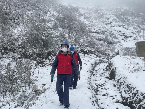 11月30日，國網(wǎng)城口供電公司員工踩著積雪巡視檢查10千伏廟羅線。王成躍攝