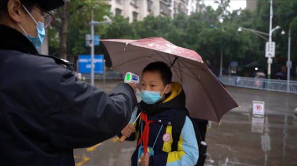 門衛(wèi)對進(jìn)校學(xué)生進(jìn)行體溫檢測。楊安東攝