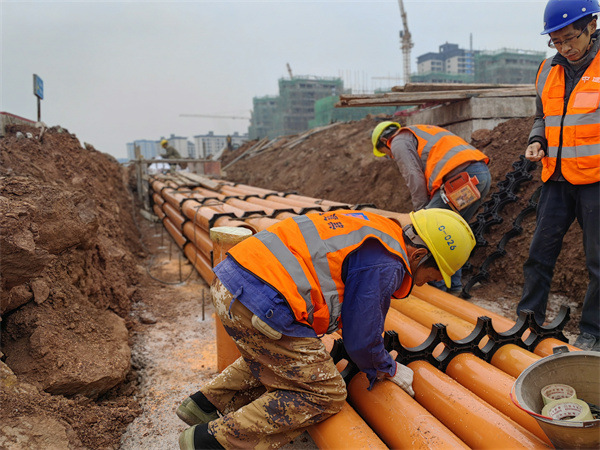 工人們正在進行地下電力管網(wǎng)安裝及回填施工。中建七局西南公司供圖