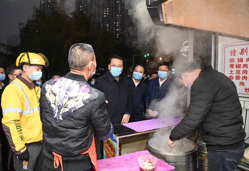 12月12日下午，在解放碑中央商務區(qū)，市委書記袁家軍同面館老板交流。記者 蘇思 攝/視覺重慶