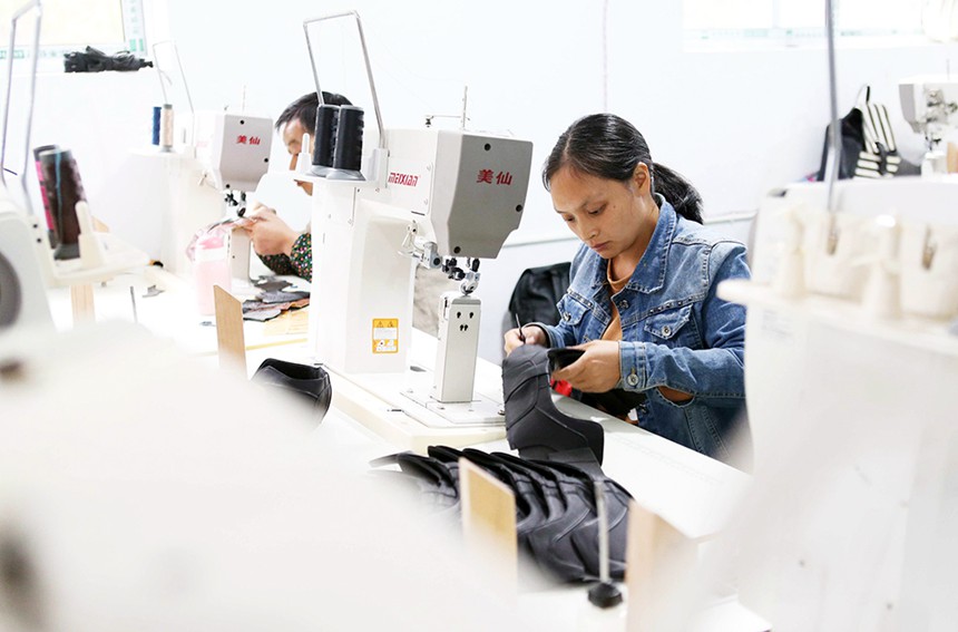 10月27日，女工在黔江區(qū)黃溪鎮(zhèn)親親制鞋廠縫制鞋幫。該鞋廠招收的50多名村民全部通過技能培訓(xùn)，加工的鞋產(chǎn)品均為海外訂單。特約攝影 楊敏/視覺重慶