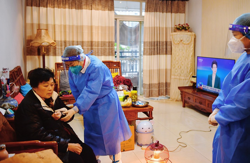 社區(qū)工作人員和醫(yī)護(hù)人員來到蔣德瓊家中為她接種新冠疫苗。周舸攝