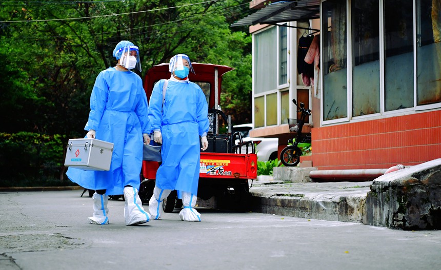 社區(qū)工作人員和醫(yī)護人員在轄區(qū)宣傳疫苗接種。周舸攝