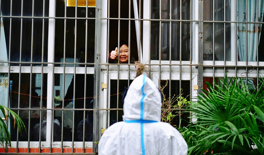 社區(qū)工作人員和醫(yī)護(hù)人員在轄區(qū)宣傳疫苗接種。周舸攝