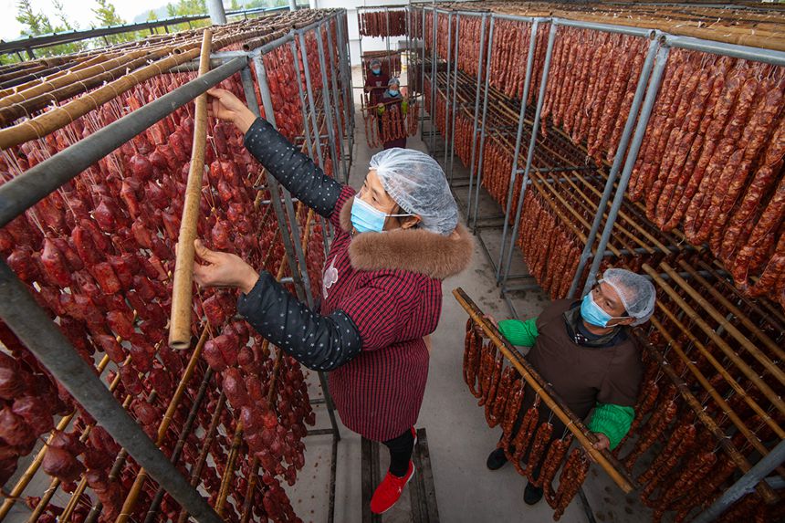 村民在寒冷中晾曬臘腸。?冉孟軍攝