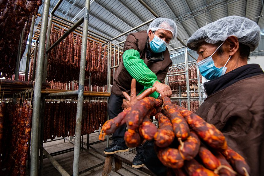 村民在寒冷中晾曬臘腸。?冉孟軍攝