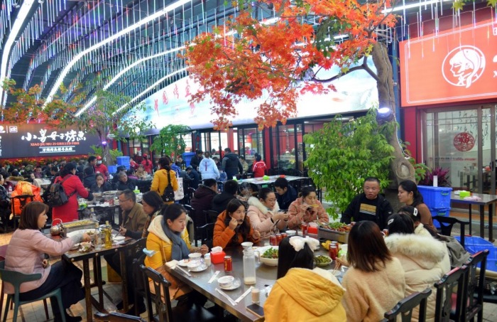 萬州區(qū)心連心廣場(chǎng)，市民品嘗鮮香烤魚。付作僑攝