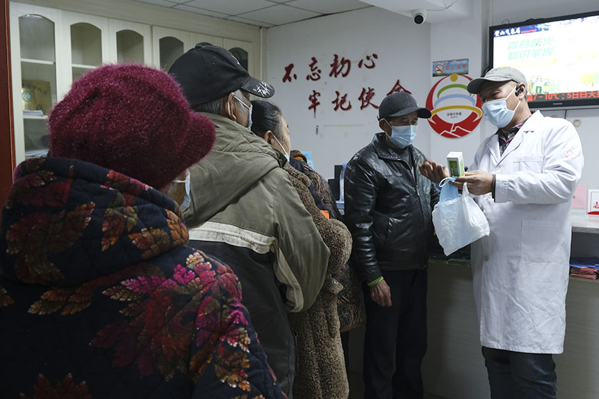 老人領(lǐng)到“健康包”后，醫(yī)生在旁耐心講解。蔣永勁攝