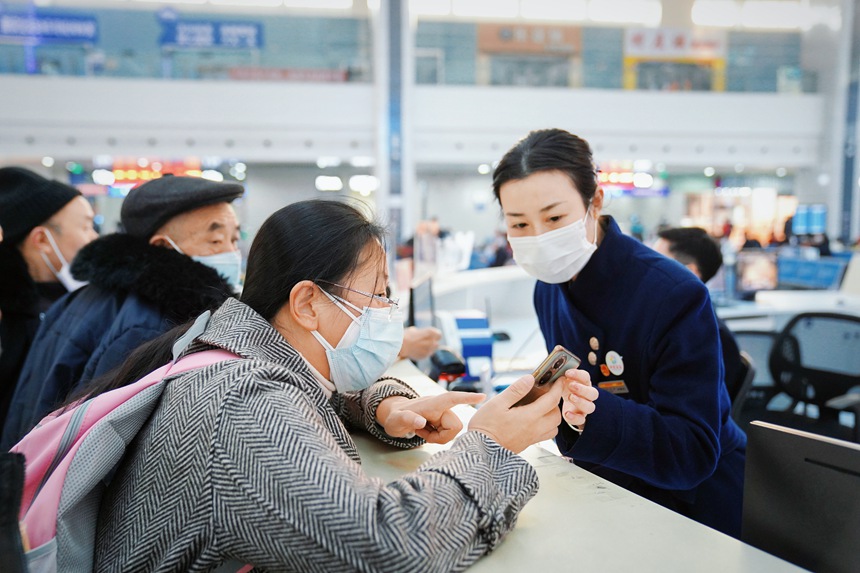重慶北站“馬廉服務(wù)臺(tái)”工作人員解答旅客疑問(wèn)。汪亮攝