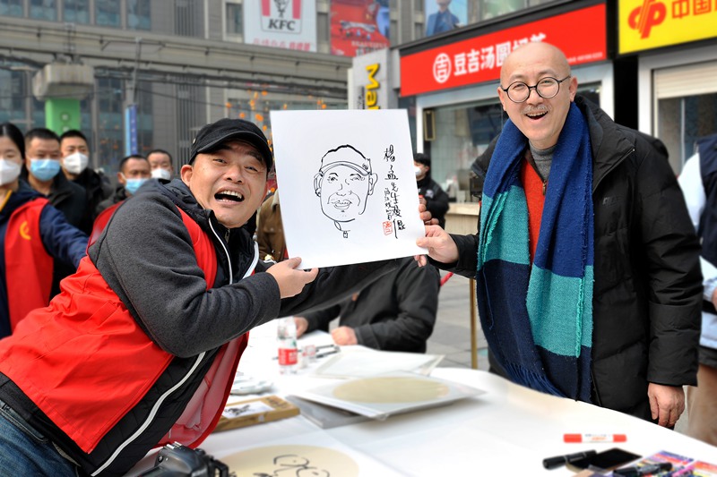 游江（右）為現(xiàn)場(chǎng)市民作畫(huà)。受訪者供圖