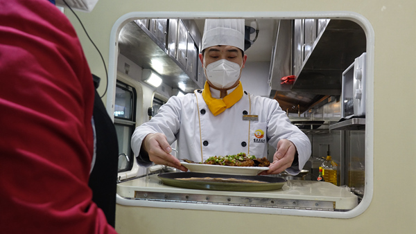 嚴(yán)鴻運端上做好的菜。李文航攝