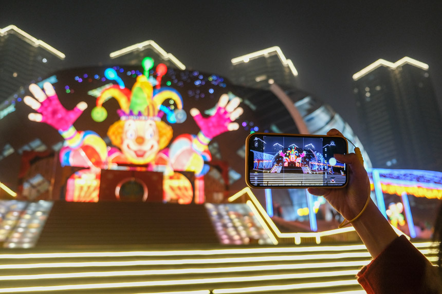 觀眾在燈飾《快樂騎士》留影。郭旭攝