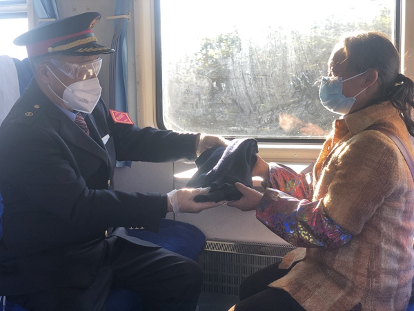 吳洪江帶給村民鄭啟梅丈夫的嶄新毛背心。張章攝