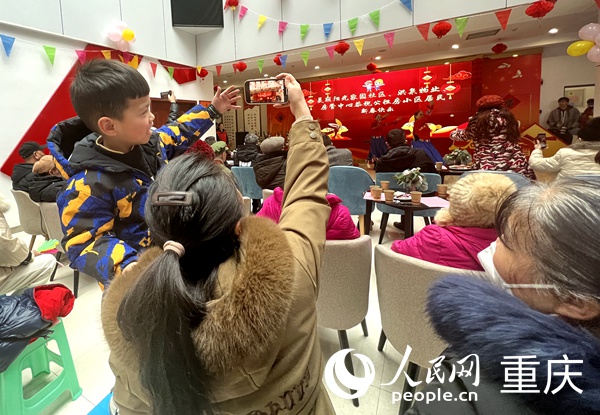 小朋友用手機(jī)記錄著歡樂的時刻。人民網(wǎng) 胡虹攝