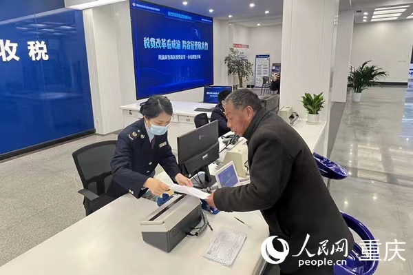 川渝高竹新區(qū)稅費(fèi)征管中心工作人員為納稅人開票。人民網(wǎng) 胡虹攝