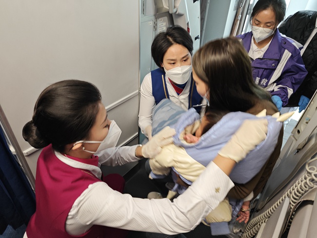 空乘人員對患病女童進(jìn)行救護(hù)。重慶航空供圖