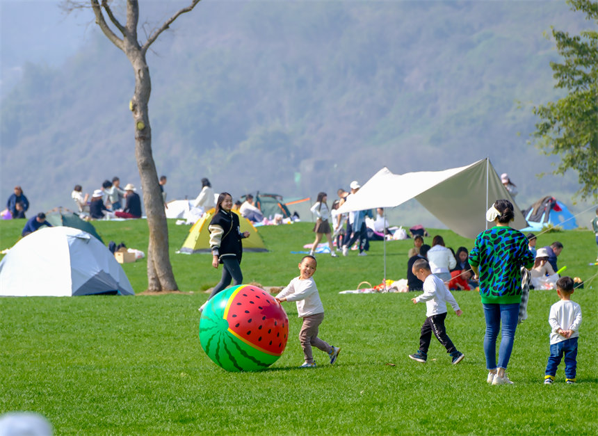 小朋友在草坪上嬉戲玩耍。郭旭攝