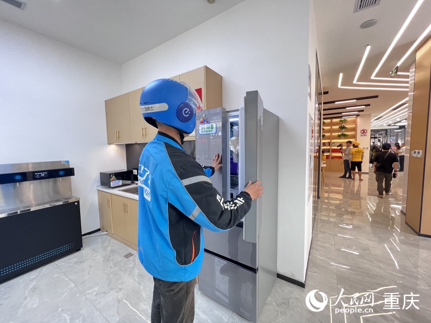 外賣小哥在冰箱里取自帶便當(dāng)。人民網(wǎng) 胡虹攝