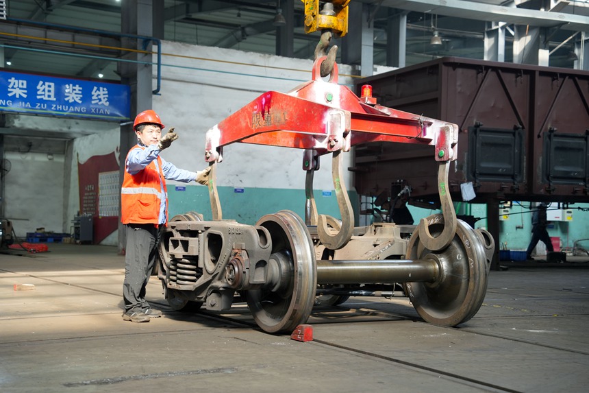 車輛鉗工正在進(jìn)行轉(zhuǎn)向架吊運(yùn)作業(yè)。吳晉超攝