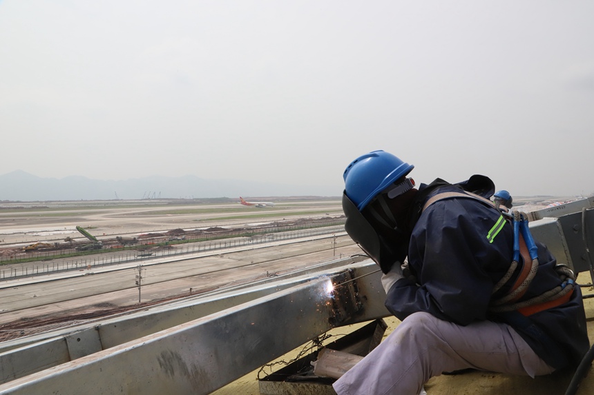 4月29日，工作人員在重慶江北國際機(jī)場T3B航站樓施工現(xiàn)場進(jìn)行屋面施工。中建八局供圖