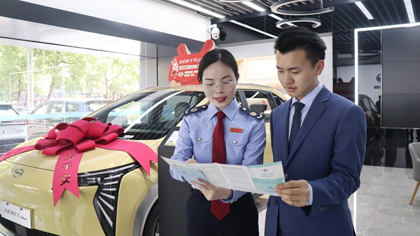 綦江區(qū)稅務(wù)人員走進江輝汽車銷售有限公司門店，為商家及消費者宣傳新能源汽車免征購置稅等稅收優(yōu)惠政策。李奕萱攝