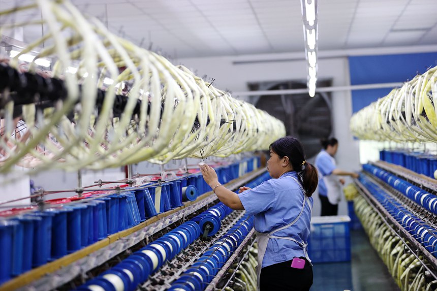 絲綢紡織女工在生產(chǎn)車間忙碌。楊敏攝