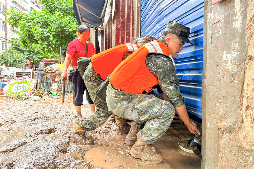 圖為武警官兵幫助受災(zāi)群眾轉(zhuǎn)移物資。李東攝