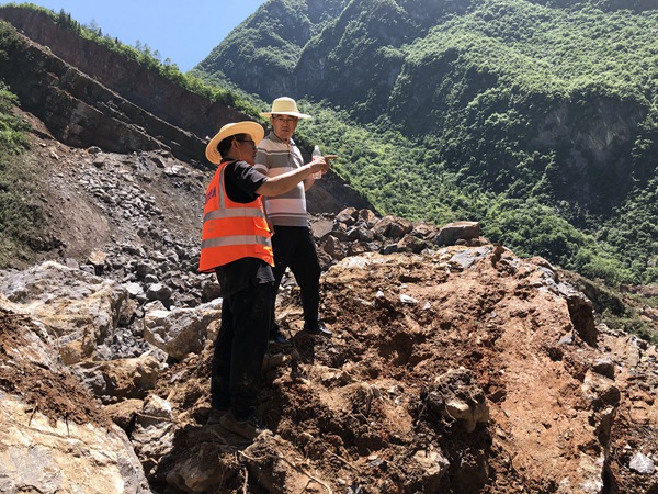 《身先士卒》。2022年6月30日，巫溪縣滑坡?lián)岆U工作中，炎炎烈日下 ，重慶市規(guī)劃和自然資源局地勘處處長李少榮（右）與208地質(zhì)隊(duì)專業(yè)總工蔣先念現(xiàn)場討論滑坡?lián)岆U方案。黎中余攝