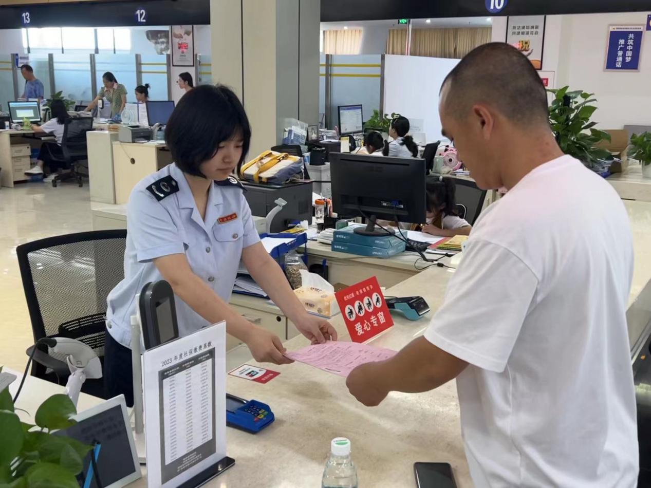 在大足區(qū)辦稅服務(wù)廳，愛心專窗稅務(wù)人員正在為殘疾人士辦理涉稅業(yè)務(wù)。蔣寧澤攝