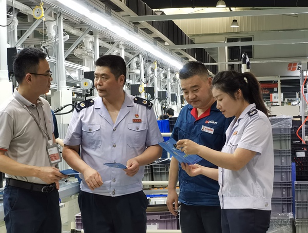 在重慶隆鑫發(fā)動(dòng)機(jī)有限公司，高新區(qū)稅務(wù)局人員宣傳輔導(dǎo)研發(fā)費(fèi)用加計(jì)扣除等稅收優(yōu)惠政策。王玉婷攝