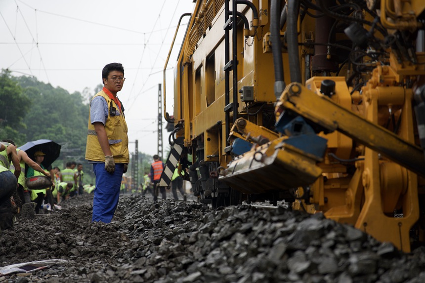 成都工務(wù)大機(jī)段職工在成渝線上指揮大機(jī)搗固。趙鵬攝