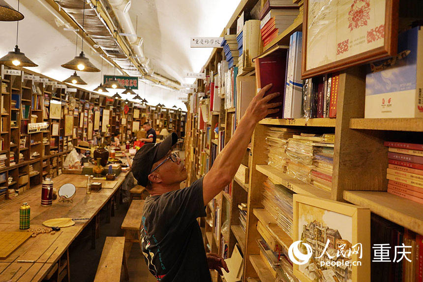 書屋負(fù)責(zé)人茍軍正在整理書架。  人民網(wǎng)記者 劉祎攝