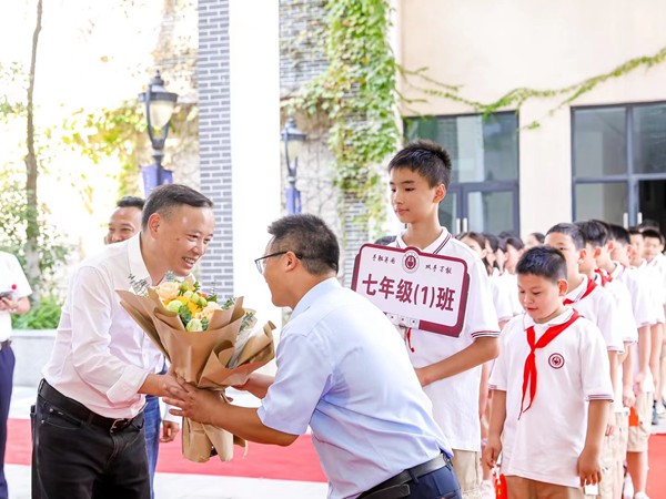 渝北區(qū)委教育工委書記、區(qū)教委主任吳云斌（左一）與黃炎培中學(xué)師生。黃炎培中學(xué)供圖