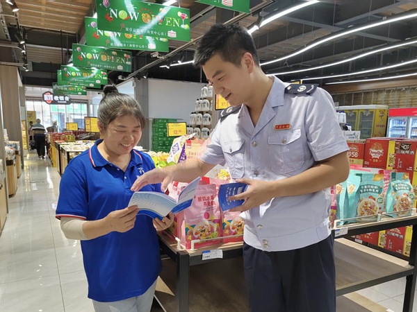 巫山縣稅務(wù)人員來(lái)到當(dāng)?shù)爻校蜕吓l(fā)零售業(yè)稅收優(yōu)惠政策宣傳冊(cè)。羅超斌攝