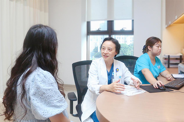 但陽(中)為患者進(jìn)行診療。重慶安琪兒婦產(chǎn)醫(yī)院供圖