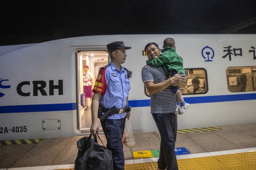 黃同川幫助旅客下車出站。胡勇攝