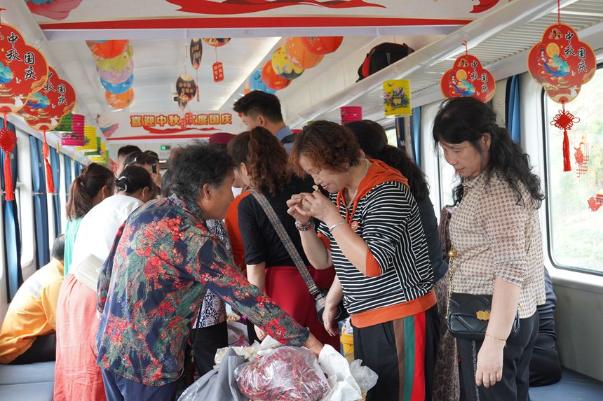 遵義開往重慶西的5630次列車上，旅客在集市車廂購買農(nóng)產(chǎn)品。李文航攝