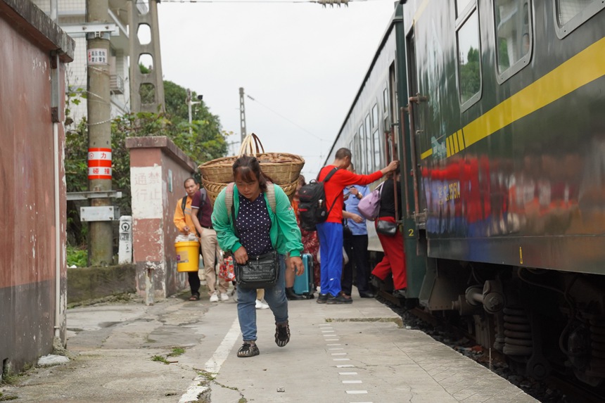 松壩站站臺(tái)，旅客背著農(nóng)產(chǎn)品登上小慢車。李文航攝