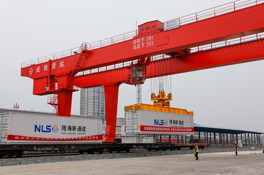 10月12日，秀山站集裝箱貨場(chǎng)內(nèi)工作人員正在使用龍門(mén)吊進(jìn)行吊裝作業(yè)。黃圯攝