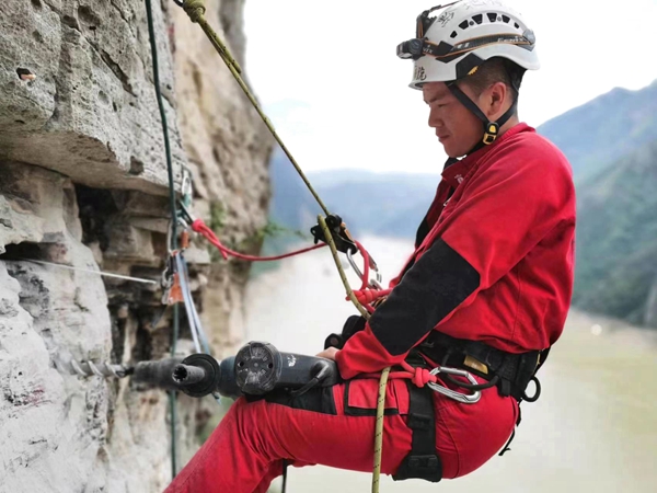 《懸崖鉆孔，安裝監(jiān)測(cè)設(shè)備》。7月下旬，重慶地質(zhì)礦產(chǎn)研究院派出的專(zhuān)業(yè)“蜘蛛人”開(kāi)展高空作業(yè)，在奉節(jié)開(kāi)展危巖隱患區(qū)域崖壁傳感器安裝工作，保障地質(zhì)安全。鄧朝松攝